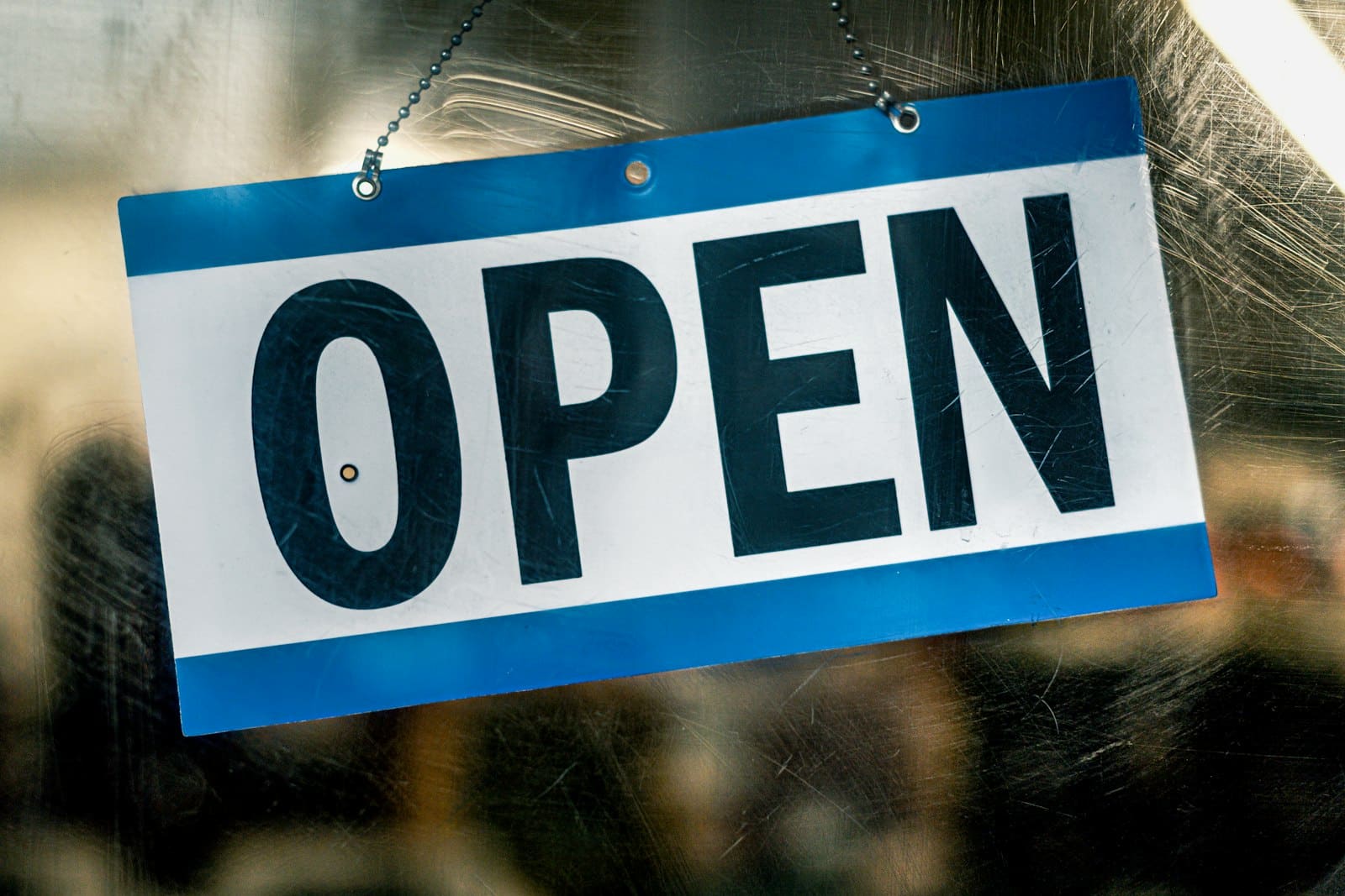 Enseigne « open » sur une porte vitrée, le site web comme porte d'entrée commerciale