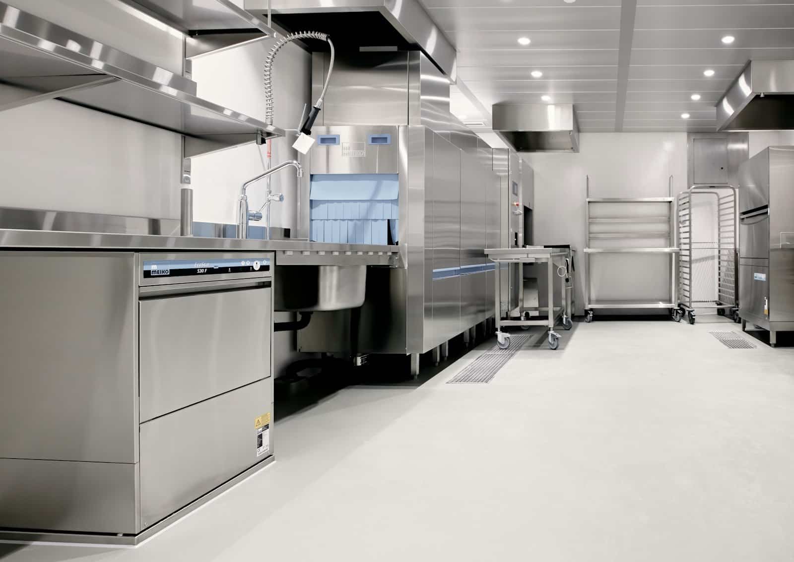 Zone de laverie en inox équipée d'un lave-vaisselle professionnel